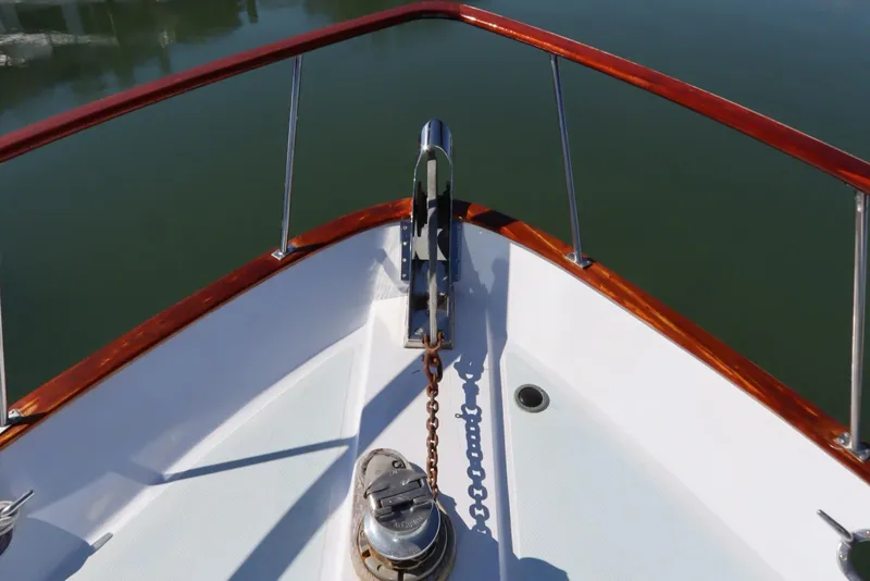 Slide: The Image of Bow of 1985 DeFever 44 Trawler with anchor chain and polished wood railing. - 44