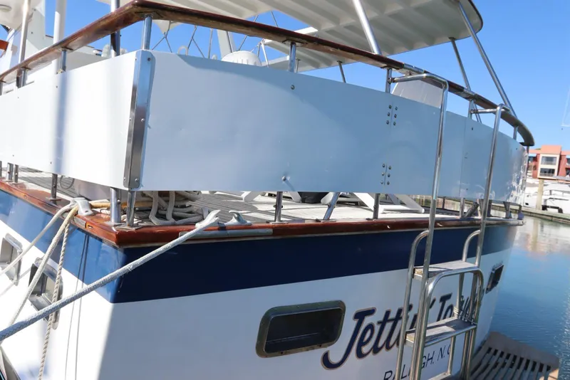 Slide: The Image of 1985 DeFever 44 Trawler docked, featuring a spacious deck and polished railing. - 5