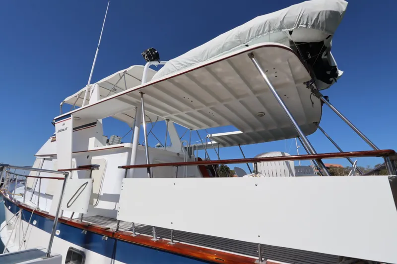 Slide: The Image of 1985 DeFever 44 Trawler with covered upper deck and clear blue sky background. - 8