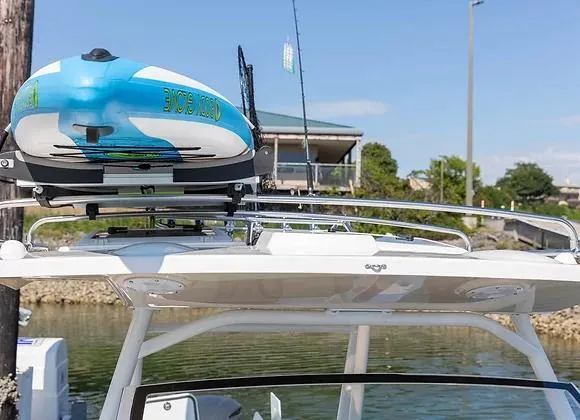 Slide: The Image of 2025 Solara 250 Center Walkaround with kayak on roof rack, docked by the water. - 13