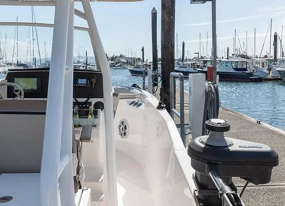 Slide: The Image of 2025 Solara 250 Center Walkaround boat docked at marina, showcasing helm and controls. - 14