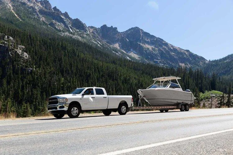 Slide: The Image of White truck towing 2025 Solara 250 Center Walkaround boat on mountain road. - 17