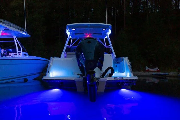 Slide: The Image of 2025 Solara 250 Center Walkaround boat with blue underwater lights at night. - 18