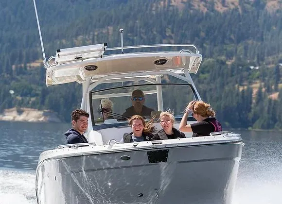 Slide: The Image of 2025 Solara 250 Center Walkaround boat cruising with passengers on a scenic lake. - 3