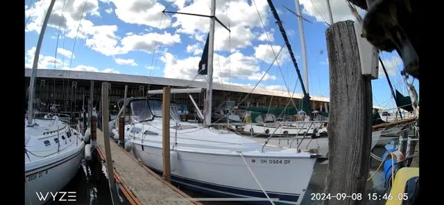 Slide: The Image of 2005 Hunter 33 sailboat docked at marina under blue sky with clouds. - 2
