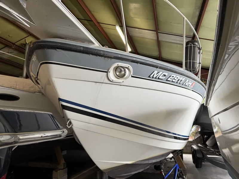 Slide: The Image of 1988 Formula 29 PC boat in storage, featuring a sleek white and blue design. - 13