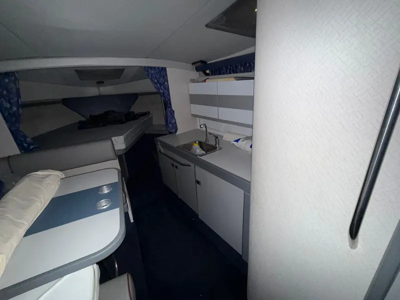 Slide: The Image of Interior of a 1988 Formula 29 PC boat, featuring a compact kitchen and sleeping area. - 17