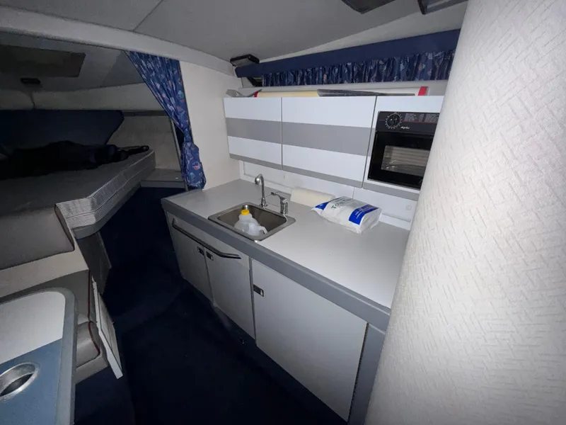 Slide: The Image of Interior of a 1988 Formula 29 PC boat, featuring a compact kitchen area. - 22