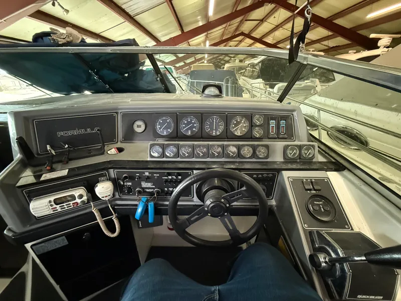 Slide: The Image of 1988 Formula 29 PC boat dashboard with gauges and controls in a marina setting. - 29