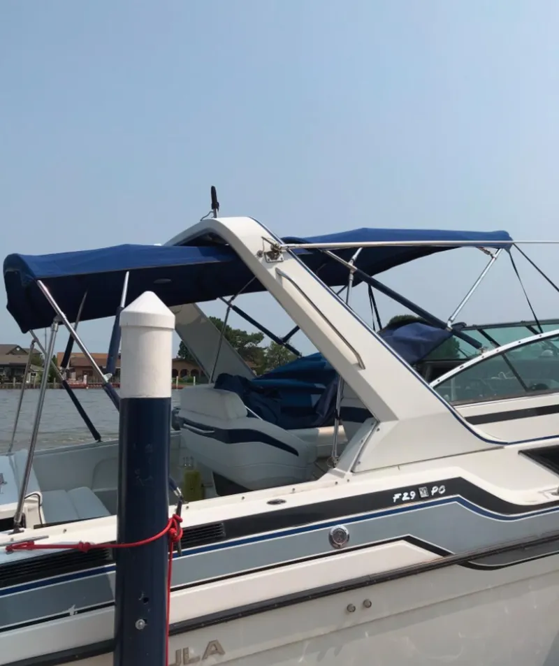 Slide: The Image of 1988 Formula 29 PC boat docked with blue canopy and sleek design. - 44