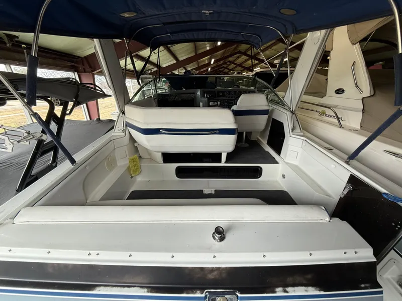 Slide: The Image of 1988 Formula 29 PC boat interior with white seating and blue accents under a canopy. - 7