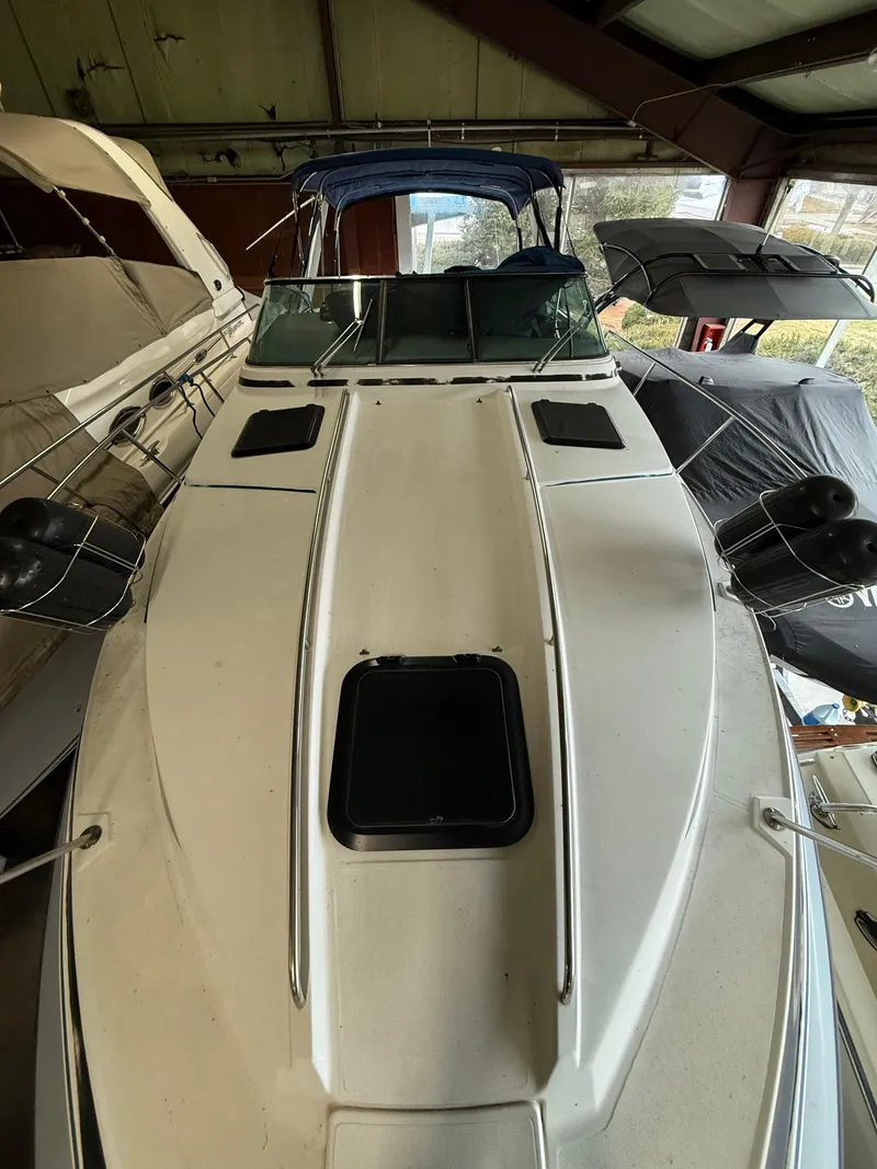 Slide: The Image of 1988 Formula 29 PC boat in storage, featuring a sleek white deck and blue canopy. - 8