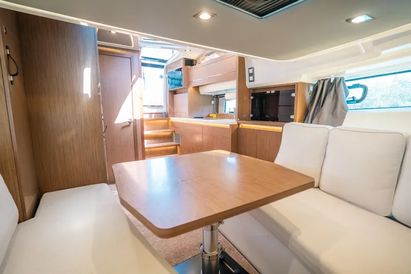 Slide: The Image of Interior of 2021 Jeanneau Leader 12.5 WA yacht with modern wood finish and seating area. - 14