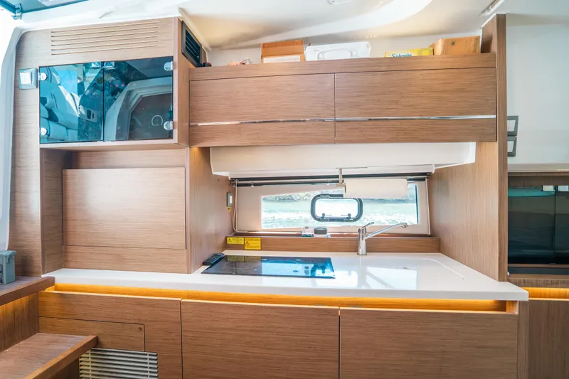 Slide: The Image of Modern kitchen interior of 2021 Jeanneau Leader 12.5 WA yacht with wood cabinetry. - 18