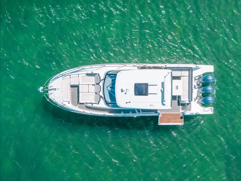 Slide: The Image of Aerial view of 2021 Jeanneau Leader 12.5 WA boat on clear green water. - 30