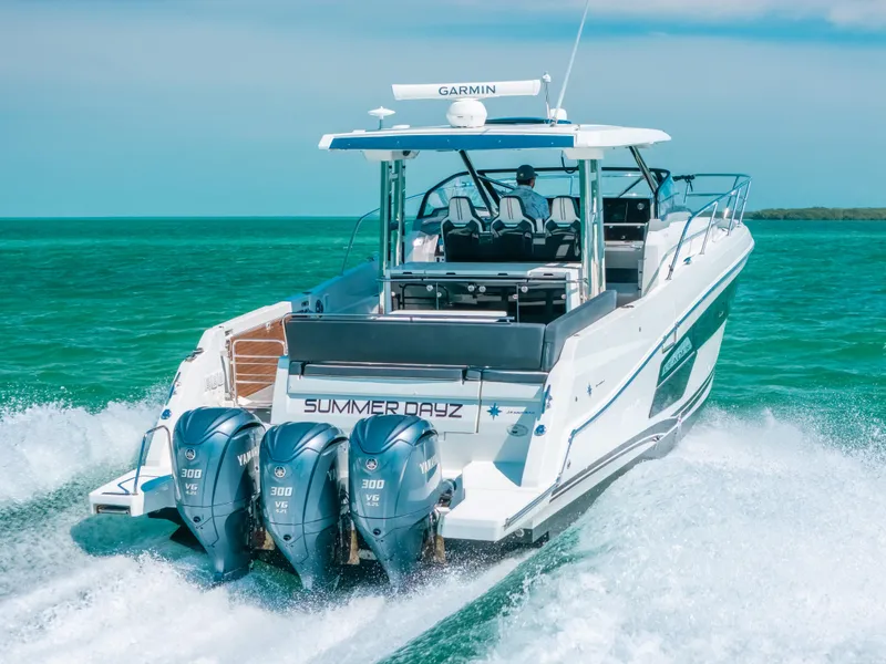 Slide: The Image of 2021 Jeanneau Leader 12.5 WA cruising on turquoise waters with triple outboard engines. - 5