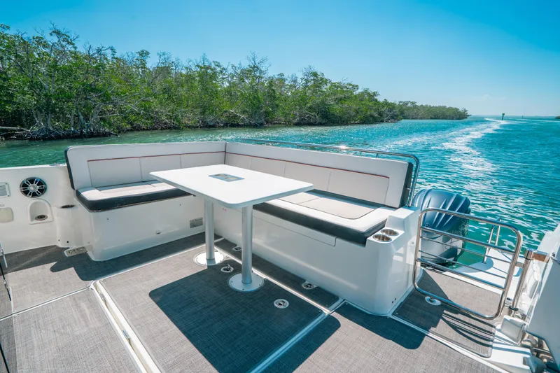 Slide: The Image of 2021 Jeanneau Leader 12.5 WA boat with spacious seating and table on deck. - 9