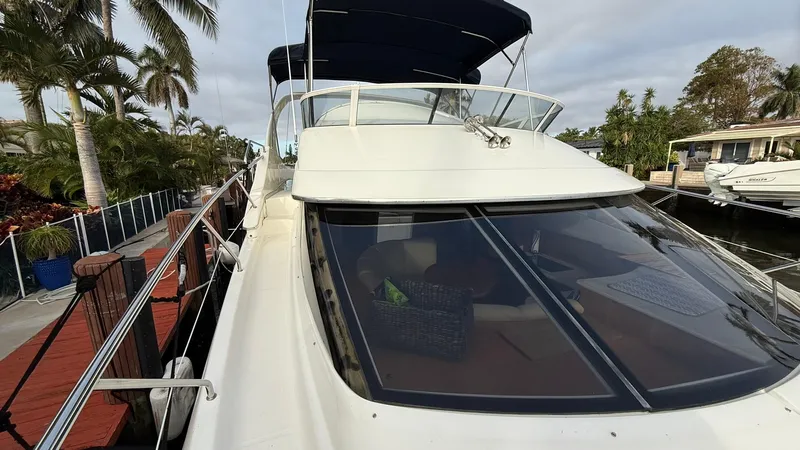 Slide: The Image of 2001 Silverton 410 Sport Bridge yacht docked near palm trees. - 10