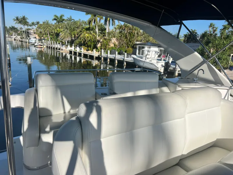 Slide: The Image of 2001 Silverton 410 Sport Bridge with white seating, docked near palm trees and calm water. - 11