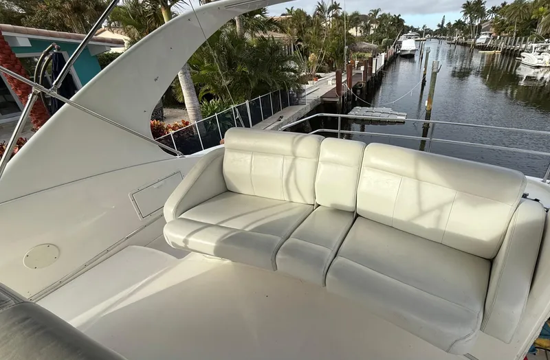 Slide: The Image of 2001 Silverton 410 Sport Bridge with white seating, docked near a canal. - 13