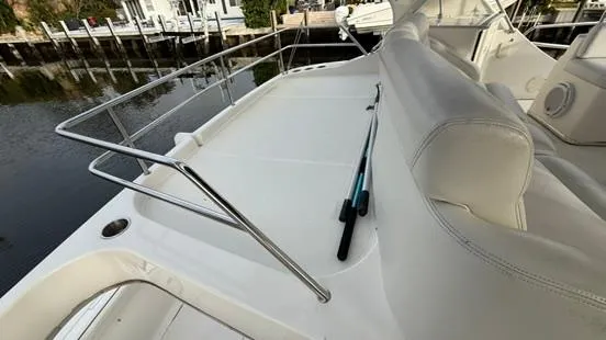 Slide: The Image of 2001 Silverton 410 Sport Bridge deck with white seating and railing, dockside view. - 14