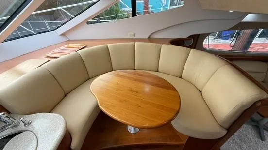 Slide: The Image of Interior of 2001 Silverton 410 Sport Bridge with curved seating and wooden table. - 29