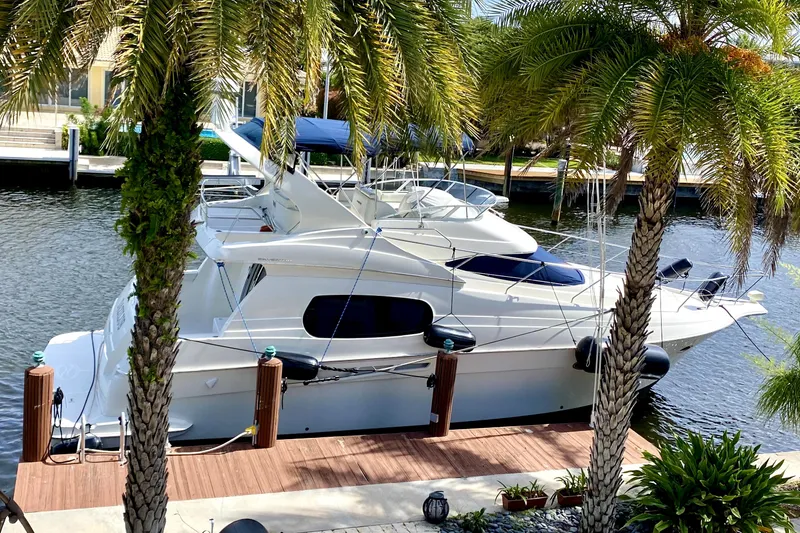 Slide: The Image of 2001 Silverton 410 Sport Bridge yacht docked by palm trees. - 3