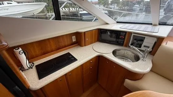 Slide: The Image of 2001 Silverton 410 Sport Bridge yacht kitchen with stove, sink, and wood cabinetry. - 33