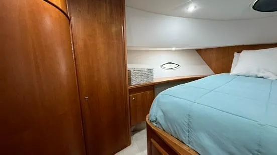 Slide: The Image of 2001 Silverton 410 Sport Bridge cabin with wood paneling and a cozy bed. - 40