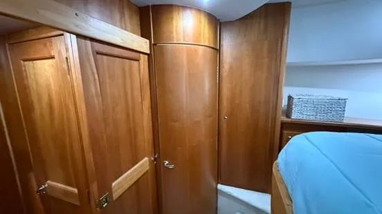 Slide: The Image of Interior cabin of 2001 Silverton 410 Sport Bridge with wooden cabinetry and blue bedding. - 41