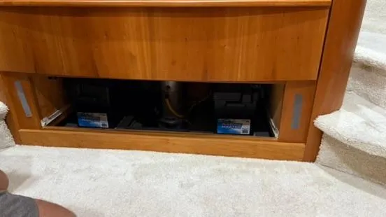 Slide: The Image of 2001 Silverton 410 Sport Bridge interior showing battery compartment under wooden panel. - 43