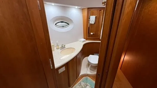 Slide: The Image of 2001 Silverton 410 Sport Bridge bathroom with wooden cabinetry and oval window. - 49
