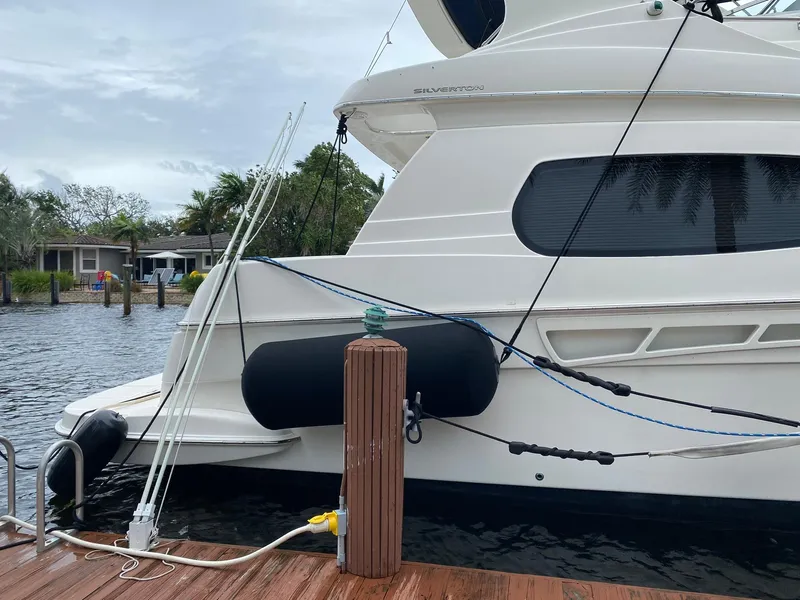 Slide: The Image of 2001 Silverton 410 Sport Bridge yacht docked by the water. - 5