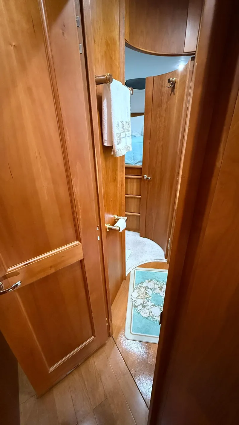 Slide: The Image of Interior of 2001 Silverton 410 Sport Bridge, featuring wooden cabinetry and bathroom entrance. - 50