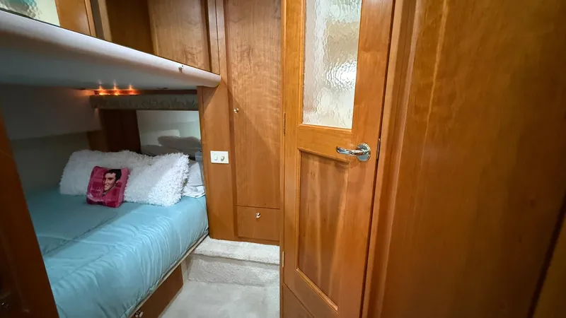 Slide: The Image of Cozy cabin interior of 2001 Silverton 410 Sport Bridge with wooden finishes and bedding. - 52