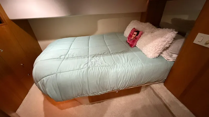 Slide: The Image of Cozy bedroom in 2001 Silverton 410 Sport Bridge with teal bedding and decorative pillows. - 53