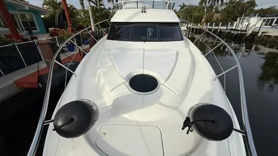 Slide: The Image of 2001 Silverton 410 Sport Bridge yacht docked near palm trees and waterfront homes. - 7