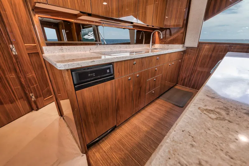 Slide: The Image of Luxurious kitchen interior of 2019 Viking 68 Convertible yacht with wood cabinetry and marble countertops. - 21