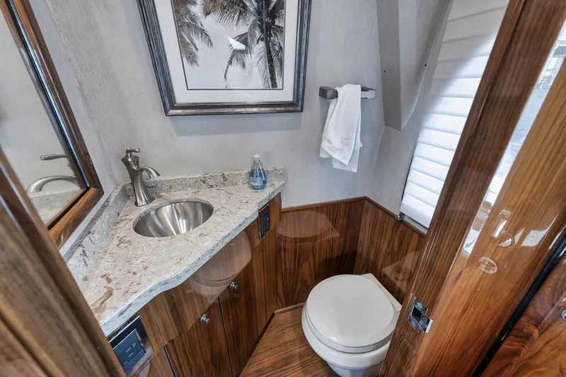 Slide: The Image of Luxurious bathroom in 2019 Viking 68 Convertible yacht with modern fixtures and elegant wood finishes. - 25