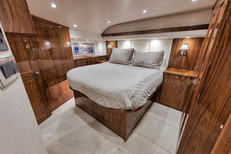 Slide: The Image of Luxurious bedroom interior of 2019 Viking 68 Convertible yacht with wood paneling and cozy bedding. - 26