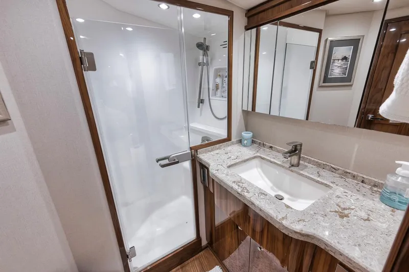 Slide: The Image of Luxurious bathroom in 2019 Viking 68 Convertible yacht with modern shower and marble countertop. - 29