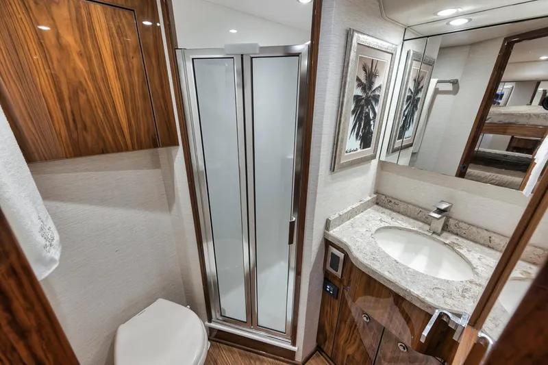 Slide: The Image of Luxurious bathroom in 2019 Viking 68 Convertible yacht with modern fixtures and elegant wood finishes. - 38