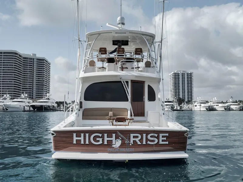 Slide: The Image of 2019 Viking 68 Convertible yacht "High Rise" docked in a marina with skyscrapers. - 4