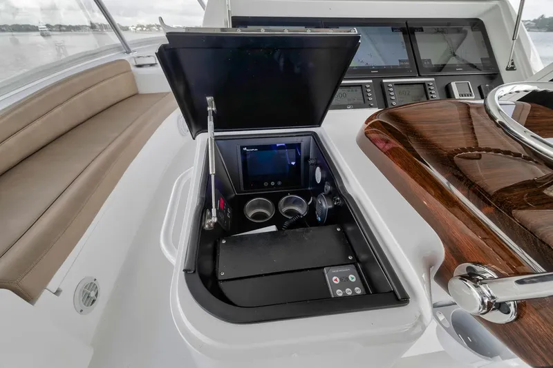 Slide: The Image of 2019 Viking 68 Convertible yacht helm with navigation controls and luxurious wood finish. - 44