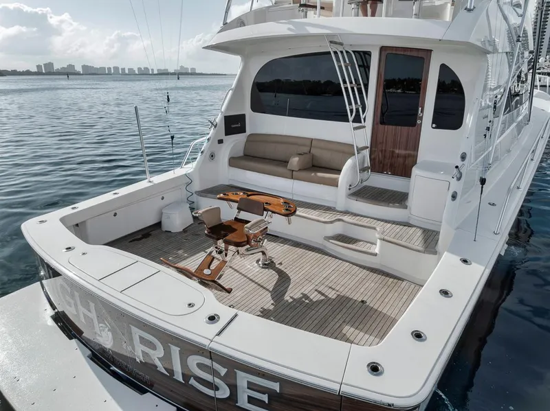 Slide: The Image of 2019 Viking 68 Convertible yacht with spacious deck and seating area on calm waters. - 5