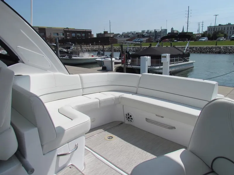 Slide: The Image of 2020 Cruisers Yachts 35 Express interior with white seating at a marina. - 10