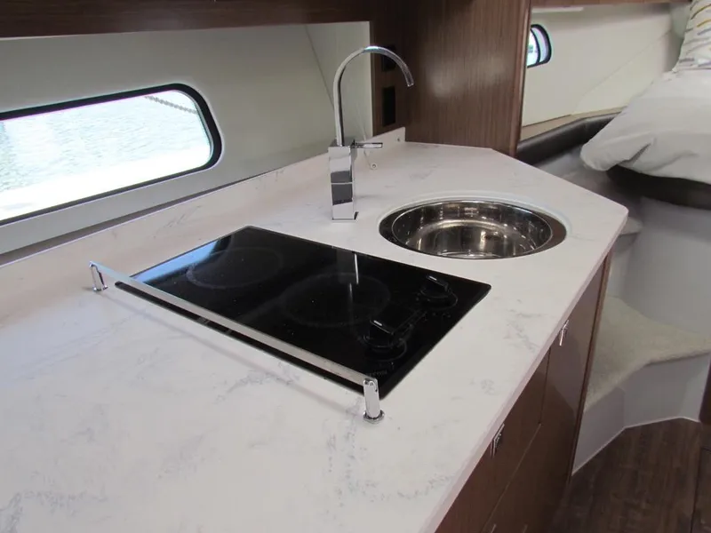 Slide: The Image of Modern kitchen area in 2020 Cruisers Yachts 35 Express, featuring stove and sink. - 15