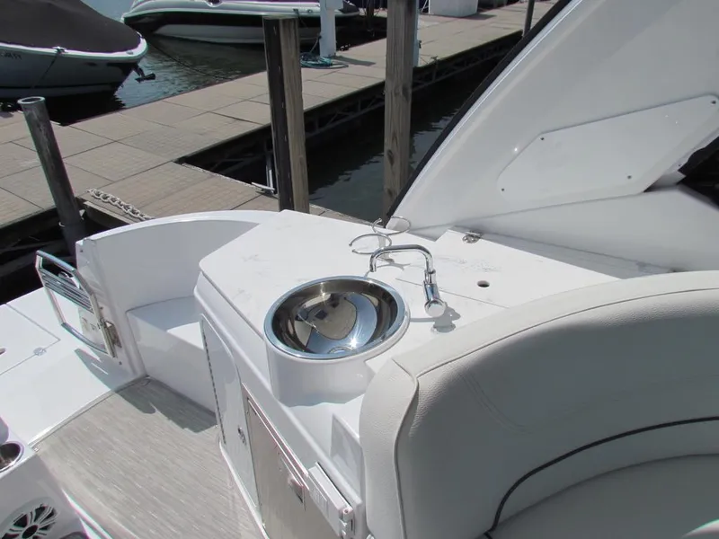 Slide: The Image of 2020 Cruisers Yachts 35 Express boat interior with sink and seating at dock. - 19