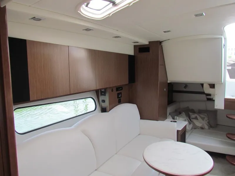 Slide: The Image of Interior of 2020 Cruisers Yachts 35 Express, featuring modern design with white seating and wood accents. - 26