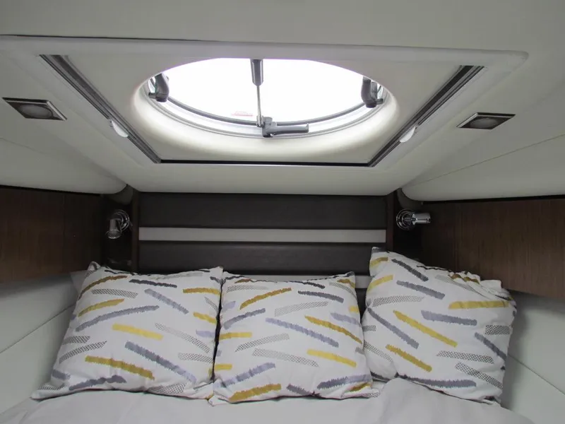 Slide: The Image of Interior cabin of 2020 Cruisers Yachts 35 Express with decorative pillows and skylight. - 3